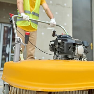 Workman applying a road sweeper on the construction site